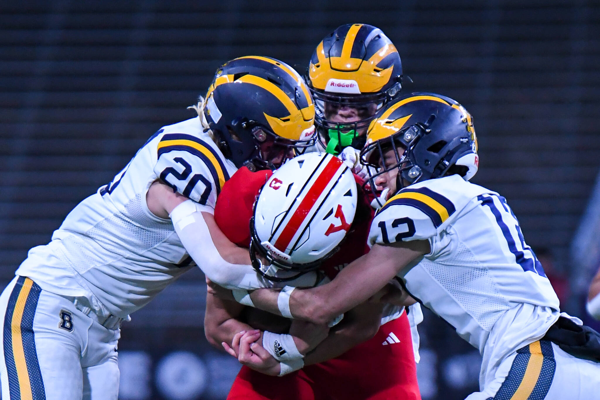 Three Bellevue players combine to stop Yelm quarterback Damian Aalona’s run, including, at left, Tate Hauser, and at right, Bryce Smith. Photo courtesy of Stephanie Ault Justus