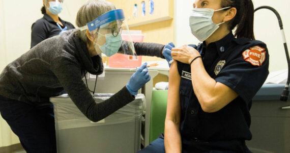 Public Health – Seattle & King County staff administering COVID-19 vaccine to a local emergency responder. COURTESY PHOTO