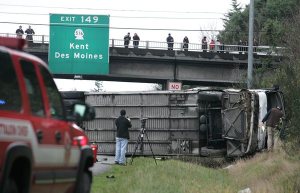 A charter bus lies on its side after it flipped Friday morning while carrying members of the Bellevue High School football team to a state playoff game. State Patrol Troopers on the scene said eight players were taken to area hospitals with injuries