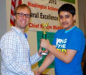 Chief Kanim Middle School science teacher Todd Henderson congratulates Bellevue seventh grader Aum Upadhyay