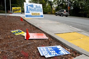 Damaged campaign signs are strewn along Forest Drive Southeast near Somerset Drvie Southeast in Bellevue on Monday. Someone sliced through many of the signs with what appeard to be a knife. Election season often finds candidates’ signs damaged. This year is no exception.