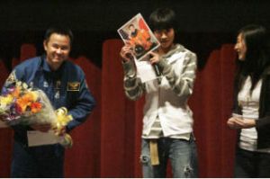 Japanese astronaut Akihiko Hoshide bows as Kojiro Narita and Momoka Nakamura show off the signed autograph to the audience after a presentation about Hoshide’s recent trip to the International Space Station. Hoshide met with students at the Sammamish High School theater on Saturday