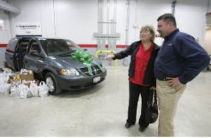 Kirmac Collision Operation Manager Leonard Lassak and Eastside Domestic Violence Program Executive Director Barbara Langdon chat in front of the van that was donated to the program.  Kirmac employees filled the van with groceries and other items used by EDVP.