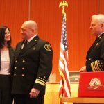 Newly promoted Deputy Chief Todd Dickerboom, center, stands with his wife Tracie as Chief Mark Risen prepares to promote him (Allison DeAngelis/staff photo).