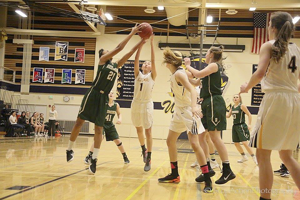 Photo courtesy of Don Borin/Stop Action Photography                                Redmond Mustangs sophomore Kiki Milloy, left, grabs a rebound against the Bellevue Wolverines on Jan. 23. The Wolverines defeated the Mustangs 57-47.
