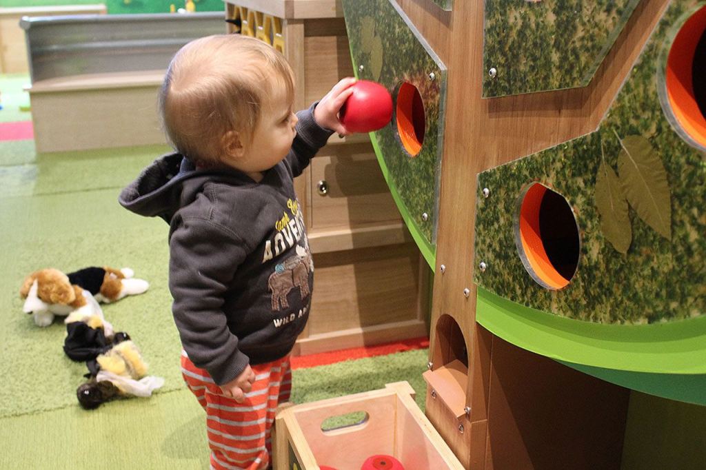 Crispin plays with a magnetic apple orchard in a toddler room (Allison DeAngelis/staff photo).