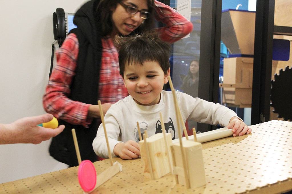 Casey Schaar creates a course for a rubber ball to travel through using a pegboard, blocks and other tools in the museum&rsquo;s &ldquo;recycling room&rdquo; (Allison DeAngelis/staff photo).
