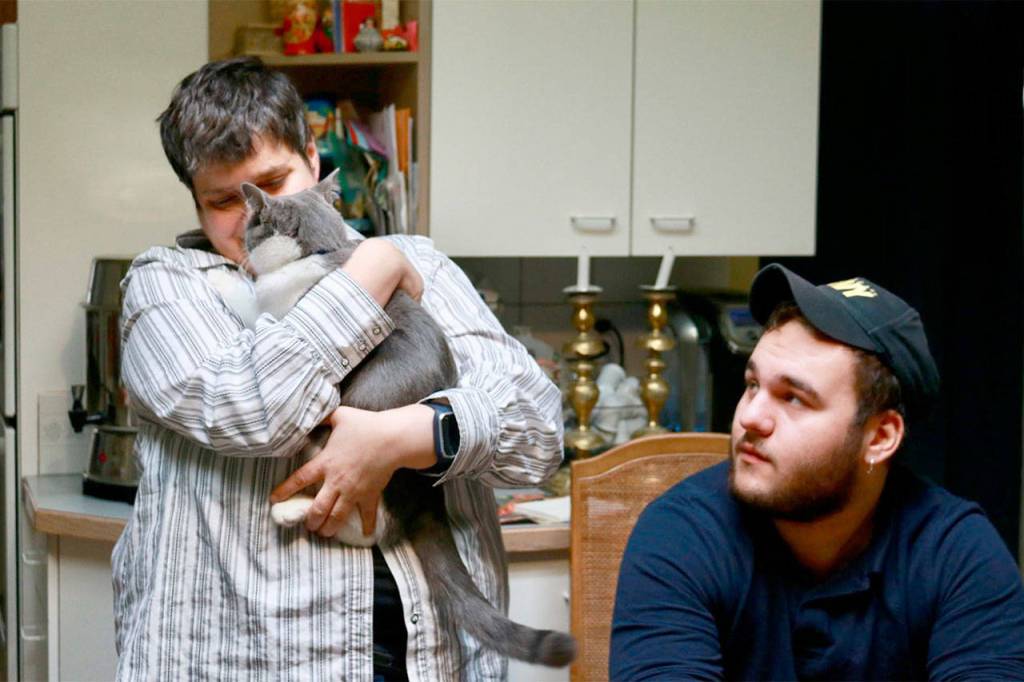 Maslan nuzzles Diesel the cat as her nephew Adam looks on. Photo courtesy of Regina Friedland