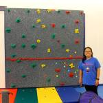 Co-owner of the Bellevue We Rock the Spectrum, Shirley Sarmiento-Blaha, stands in front of the gym&rsquo;s rock wall. Raechel Dawson/staff photo