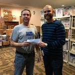From left, Rich Bowen, the director of Renewal Food Bank accepts the donation from Chris Bentvelzen, owner of Shoes-n-Feet. Photo courtesy of Adam Stuhlfaut