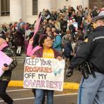 The dozen or so counter protesters on hand included Aquila Krause, shown here speaking with a Washington State Patrol officer near the Temple of Justice at the Capitol. Photo by Taylor McAvoy