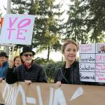 Chris Petzold, organizer at Indivisibles of Washingtons 8th District, holds up a sign along with other attendees of the rally. Evan Pappas/Staff Photo