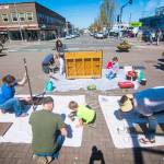 A work party on Saturday prepares Port Angeles downtown piano for a makeover on Saturday. (Jesse Major/Peninsula Daily News)
