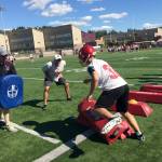 Newport Knights head football coach Drew Oliver, center, encourages one of his players during footwork drills on the first day of spring football practice sessions on June 11 at Newport High School in Factoria. Shaun Scott/staff photo