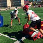 Newport Knights head football coach Drew Oliver, center, encourages one of his players during footwork drills on the first day of spring football practice sessions on June 11 at Newport High School in Factoria. Shaun Scott/staff photo