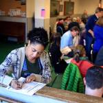 Nashika Hadley fills out a registration form during the 2016 Democratic caucus at the Everett Labor Temple in Everett. (Kevin Clark / Herald file)