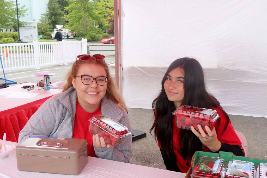 Lindsay McNally, Interlake High School, and Alohi Holing, Sammamish High School, volunteer at the strawberry booth selling fresh strawberries. Evan Pappas/Staff Photo