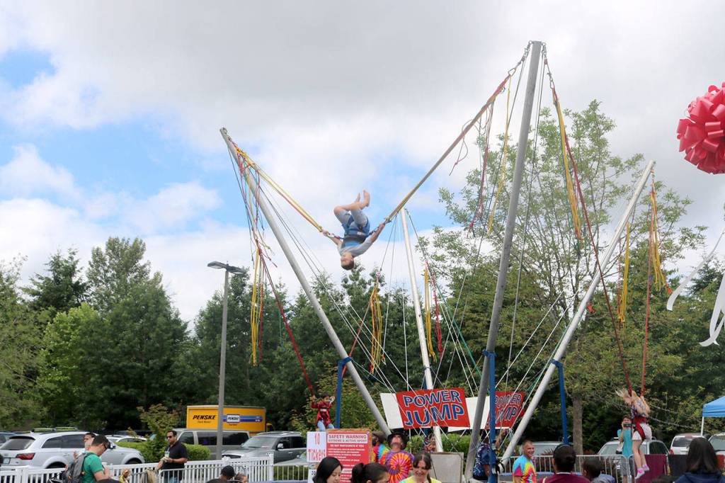 Kids strap into a harness to get massive air time on the trampoline. Evan Pappas/Staff Photo