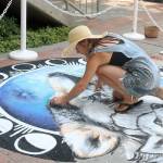 Gabrielle Abbott, an award-winning chalk artist, muralist, and fine artist from Seattle, does live art on the brick flooring near the door to the mall. Evan Pappas/staff photo