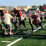 Newport offensive coordinator Eric Peterson, who is known for his fiery passion as a leader, leads the Knights through sled drills in the final minutes of practice on Aug. 17. Shaun Scott/staff photo