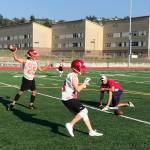 Newport Knights quarterback Tre Louis, left, throws a seam route to a wide receiver during an evening practice session on Aug. 17 at Newport High School in Factoria. Knights head coach Drew Oliver, right, snapped Louis the ball on the play. Shaun Scott/staff photo