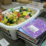 Table of school supplies waiting to be organized and sorted into backpacks. Madison Miller/staff photo.