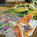 Table of school supplies waiting to be organized and sorted into backpacks. Madison Miller/staff photo.