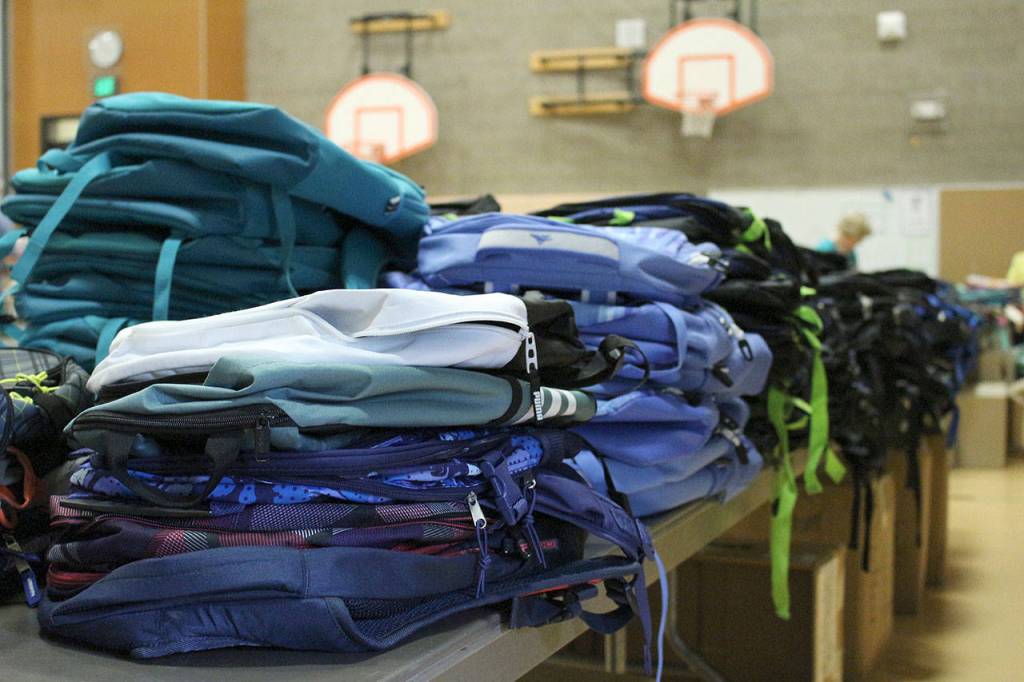 Table of new backpacks waiting to be filled with school supplies. Madison Miller/staff photo.