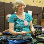 Linda Detering attaching tags to backpacks as each order is filled. Madison Miller/staff photo.