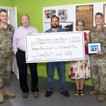 Carlson, far left, and Wilson, far right, donate their money they raised to Habitat for Humanity in the Thousand Island area of New York. Courtesy Photo