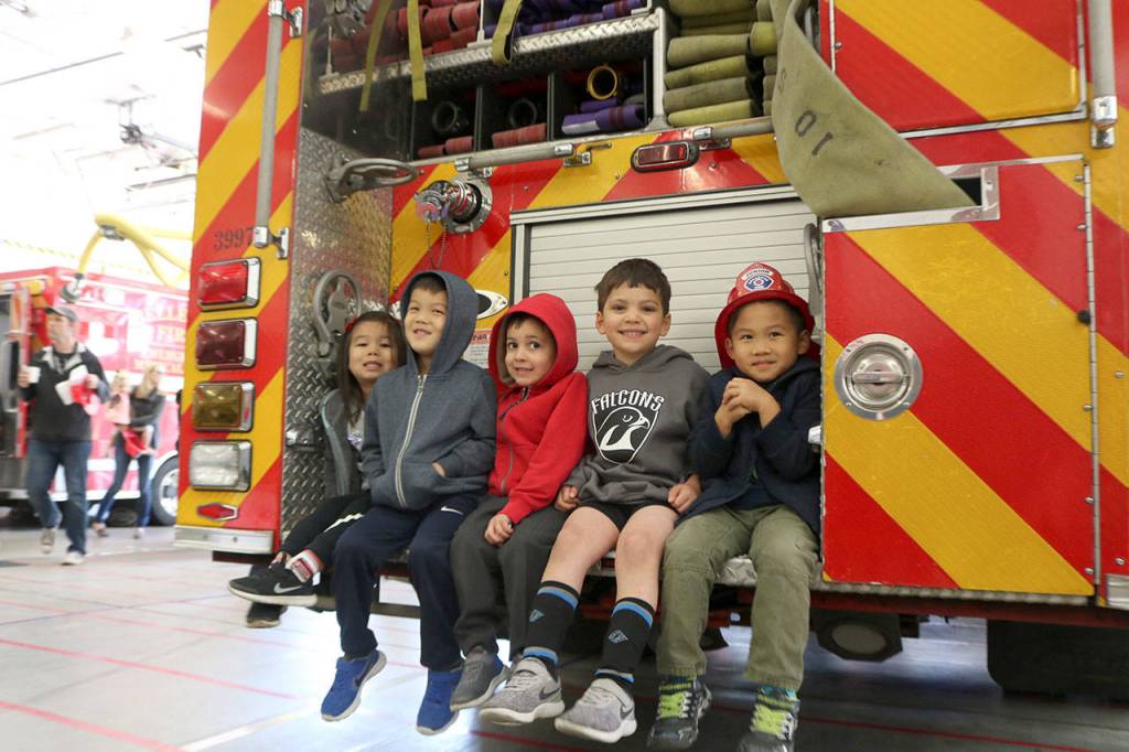 Kids at the Fire Departments open house sit together on the back of a Fire Engine. From left: Olivia Chan, Aiden Chan, Philip Farah, James Farah, and Austin Vo. Evan Pappas/Staff Photo