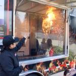 Deputy Washington State Fire Marshal Lysandra Davis, left, explains the benefits of a home sprinkler system during a demonstration of the sprinkler response time. Evan Pappas/Staff Photo