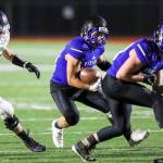 Bellevue Christian Vikings running back John Kim, center, battles for extra yardage against the Klahowya Eagles in the season finale on Nov. 3 at Sammamish High School in Bellevue. The Eagles defeated the Vikings 21-0, eliminating the Vikings from playoff contention. Photo courtesy of Rick Edelman/Rick Edelman Photography