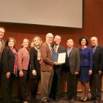 The Bellevue City Council presents Pamela Toelles family with an official commendation for her years of work in the city. From left: Jared Nieuwenhuis, Jennifer Robinson, Mary Worley, Liz Bohlin, Alan Toelle, John Chelminiak, Conrad Lee, Lynne Robinson, John Stokes, and Janice Zhan. Evan Pappas/Staff Photo