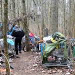 In this photo from January 2017, a Federal Way police officer walks through the remains of a homeless encampment in Federal Way. File photo
