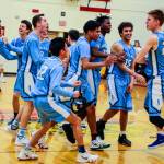 Interlake Saints players mob sophomore center Derek Kramer, right, following their dramatic 51-50 win against the Lake Washington Kangaroos in a loser-out playoff game on Feb. 6 at Newport High School in Factoria. Kramer hit two free throws with 5.7 seconds left in the game, giving his team a 51-50 lead. Photo courtesy of Don Borin/Stop Action Photography