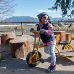 Vivian, one of many cared for at a child care center of the Kiwassa Neighbourhood House in Vancouver, B.C., spends the day outside on a tricycle on March 21. The site was awarded prototype status by the government of British Columbia as part of an effort to ease skyrocketing child care costs in the province. Ashley Hiruko/staff photo