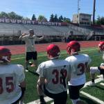 Newport Knights head football coach Drew Oliver gives his players advice on the importance of proper technique during a spring football practice session on June 10 in Factoria. Shaun Scott/staff photo
