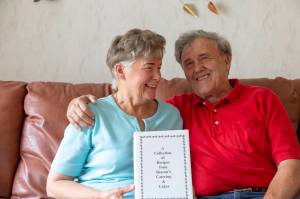 Ashley Hiruko/Staff photo                                Sharon and Dallas Graham in their Bellevue home, where they ran their cake and catering business out from. Sharon holds a cookbook she created.