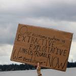 A sign at the Kirkland climate strike at Houghton Beach Park Friday. Our economic system is extractive, exploitative and unsustainable. We need change  Now. Madison Miller/staff photo