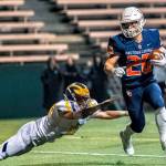 Bellevue senior Alex Reid (left) dives after Eastside Catholic running back Gio Ursino (right) during a 3A state quarterfinal game on Nov. 23. Photo courtesy of Patrick Krohn/Patrick Krohn Photography