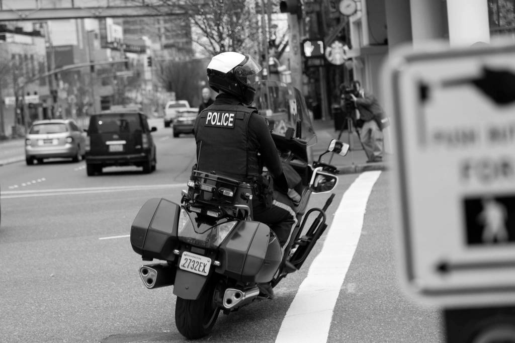 A Bellevue officer follows a car that turned on red without legally required amount of lane space. Motorists who did this were given a warning and educated on what driving law states. Ashley Hiruko/staff photo