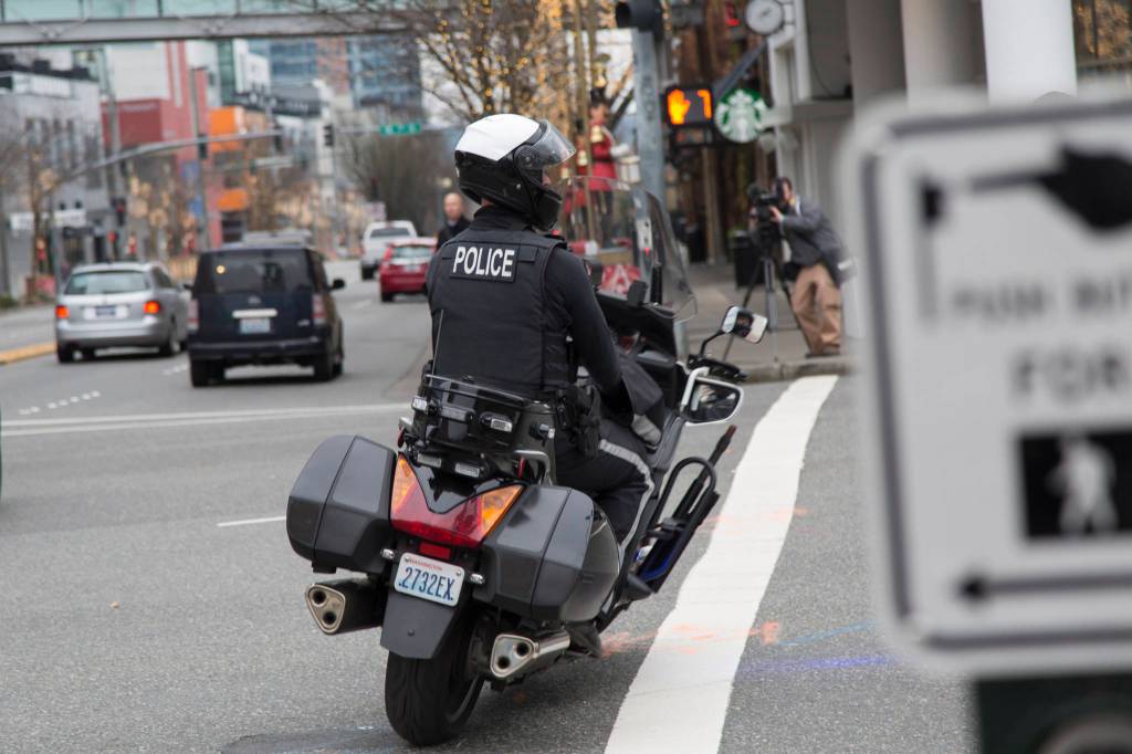 A Bellevue officer follows a car that turned on red without legally required amount of lane space. Motorists who did this were given a warning and educated on what driving law states. Ashley Hiruko/staff photo