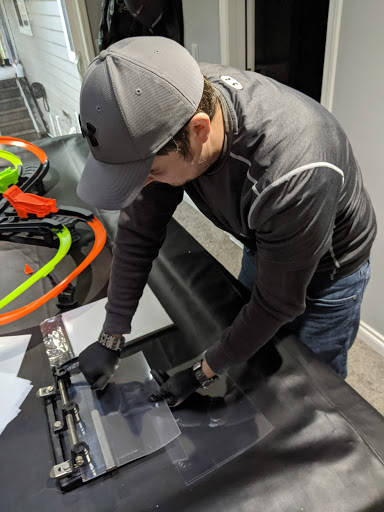 Ryan Schwalb punches holes in a transparent film to attach the face shield to a mask frame, creating personal protection equipment for frontline health care workers. Photo courtesy of Ryan Schwalb
