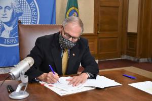 Gov. Jay Inslee, pictured in December as he signed the certified statewide election results. Courtesy photo