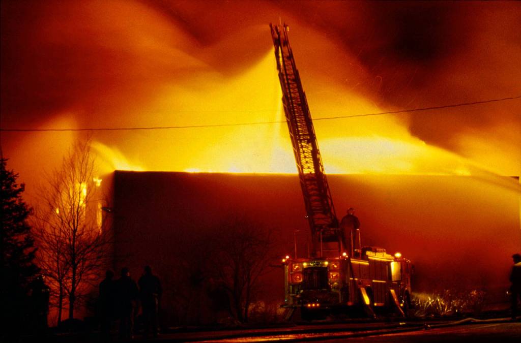 A ladder truck shoots water over the south wall of the Everett Community College library complex on Feb. 16, 1987. The arson destroyed the facility and killed Everett firefighter Gary Parks. (Michael OLeary / Herald file)