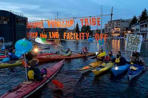 Protesters hold a sign near PSE Mary Kipps house (photo credit: Neal Anderson)