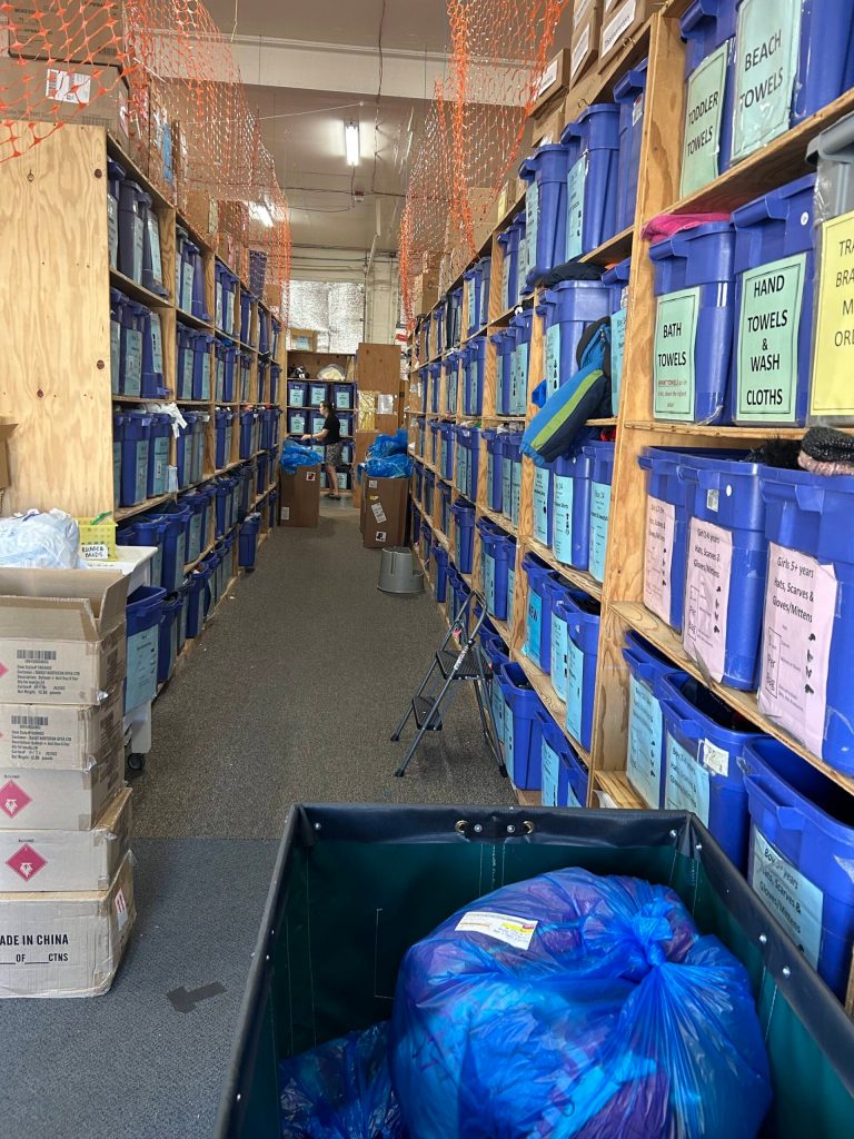 Bins for every article of clothing fill the custom-made shelving. The bundle in the corner is ready to be picked up. The bundle is packaged according to the white order label stuck to the bag. (Photo by Cameron Sires)