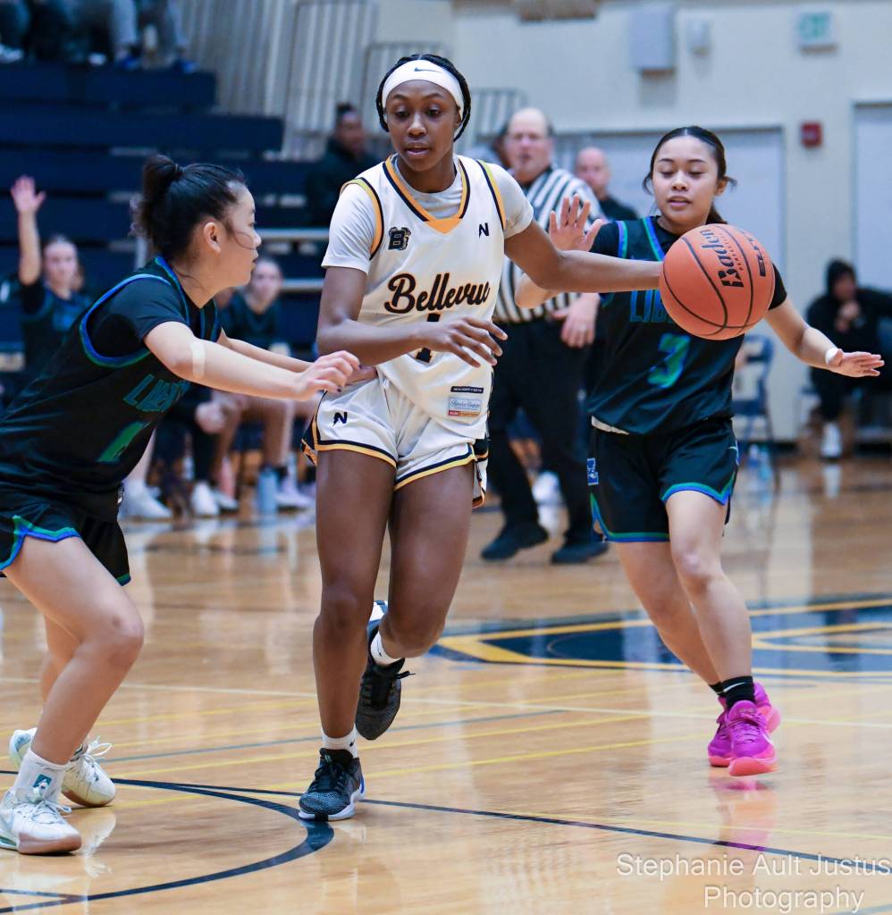 Bellevue freshman Dilynn Johnson drives past Liberty junior Marlee La Madrid, right, and Liberty senior Addison Tran, left. Photo courtesy of Stephanie Ault Justus