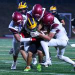 Bellevue High senior Max Jones carries the ball while three Bethel players tackle him. Bethels players are senior Zak Fruean, senior Jayden Miller and sophomore Mason Dutcher. Photo courtesy of Stephanie Ault Justus
